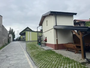Teren kwater pracowniczych w Bibicach: podjazd, parking i dwa budynki mieszkalne